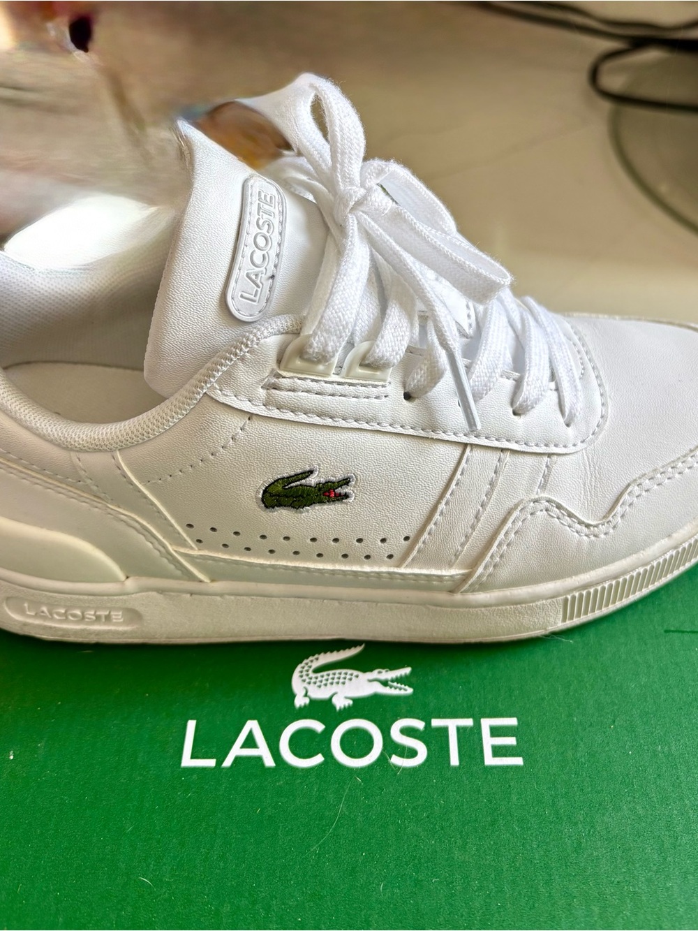Lacoste Women’s sneakers with a distinctive green crocodile accent.